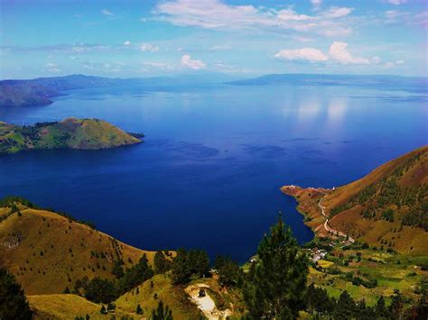 Danau Toba: A Volcanic Super-Lake Embraced by Misty Mountains!